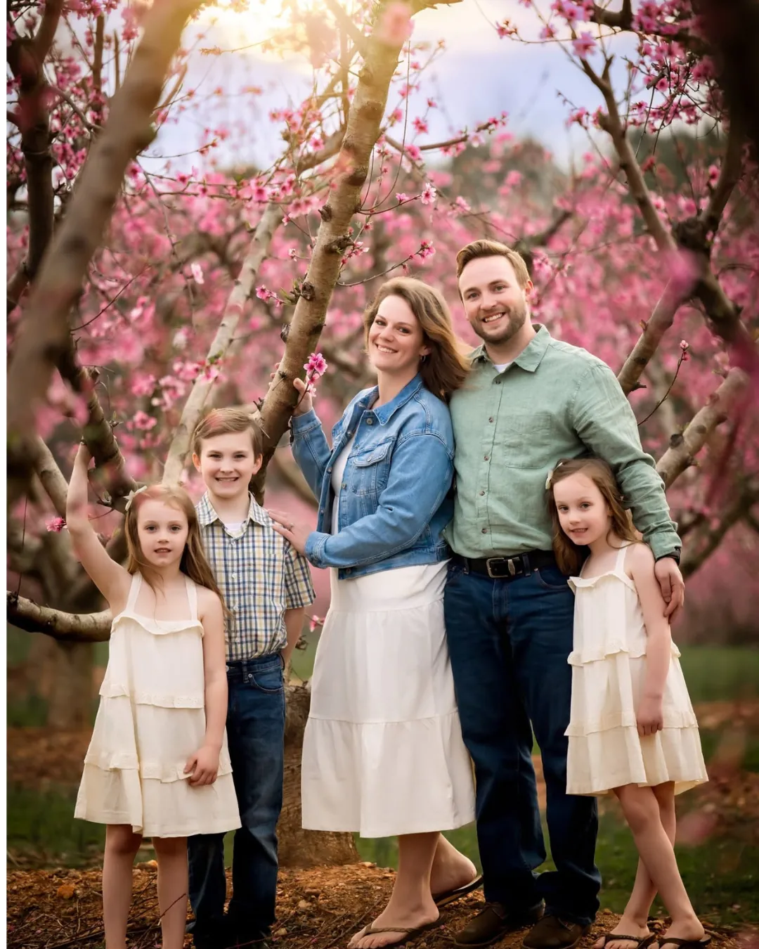 Family portrait session among blooming peach trees