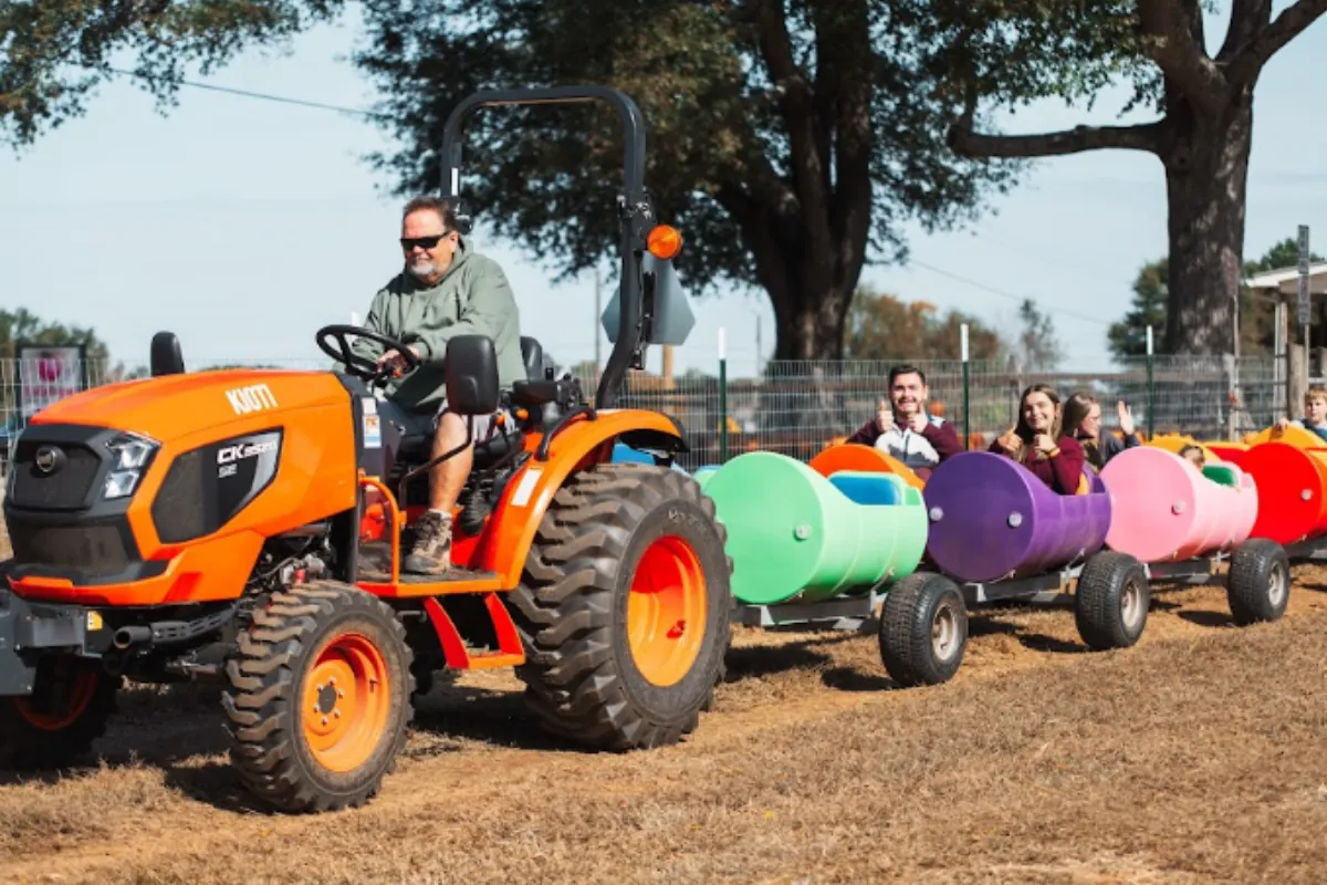Kids and adults riding the train through the fall festival grounds.