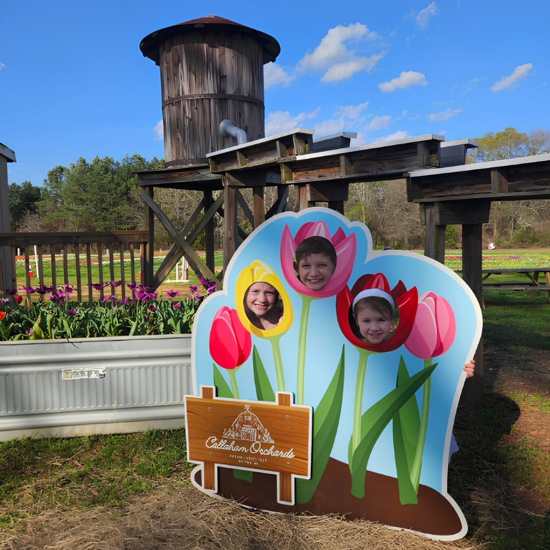 Children posing with a tulip photo cutout board at Callaham Orchards