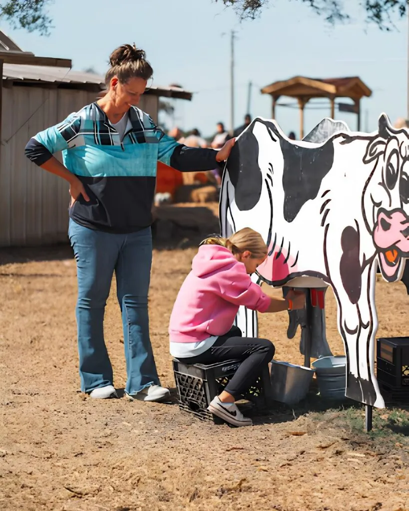 Child trying the cow milking station demonstration